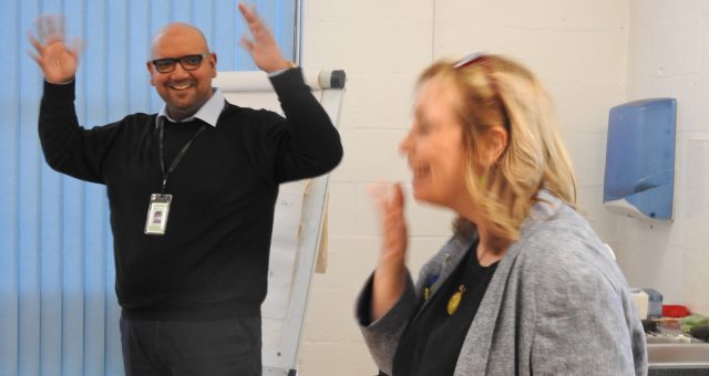Image of a BSL Tutor waving their hands in a BSL Clap motion, while a learner signs thank you.
