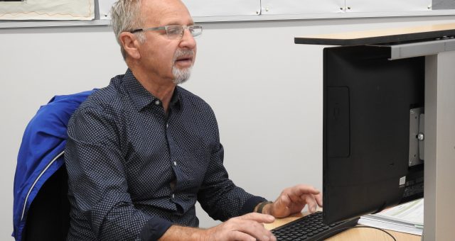 An image of a Digital Skills learner typing on a keyboard looking at the screen