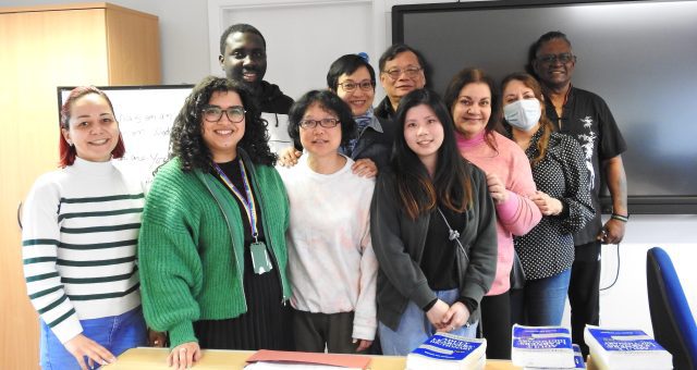 An image of a large group of ESOL learners standing with their Tutor and smiling for the camera.