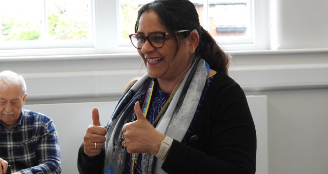 An image of an ESOL tutor putting two thumbs up