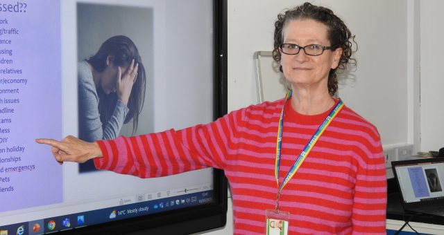 An image of a mental health tutor pointing at a screen