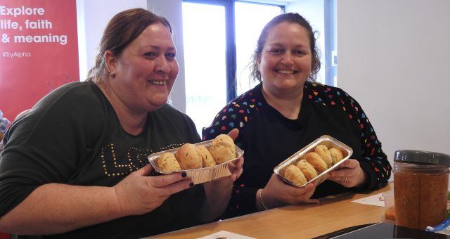 Two learners hold up their scones baked in class.