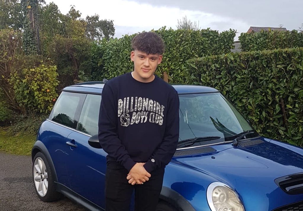 Image shows Payroll graduate Corbyn, posing for the camera Infront of his beloved car.