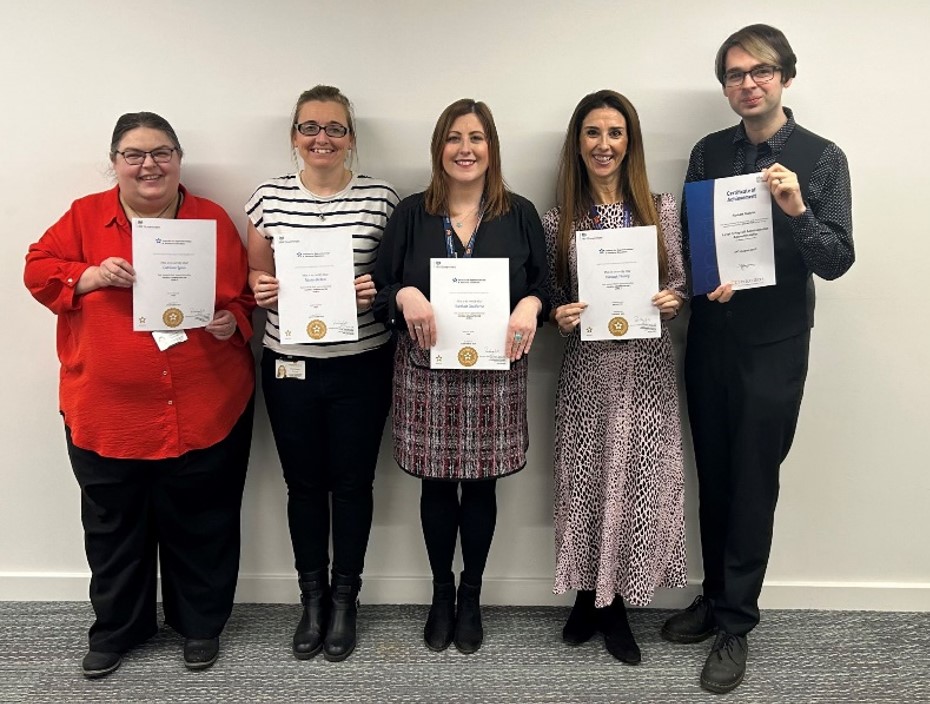 A group of five employees from northumberland county council stand holding up their certificates